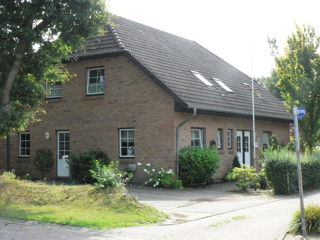 a brown brick house with a black roof at Ferienwohnungen Torfweg in Weddingstedt