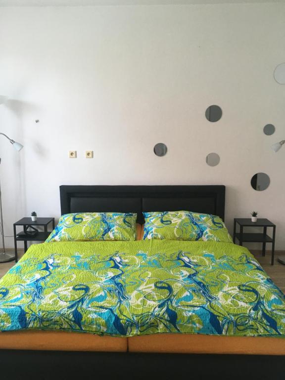 1 dormitorio con 1 cama con un edredón colorido en Sportovni apartman, en Náchod