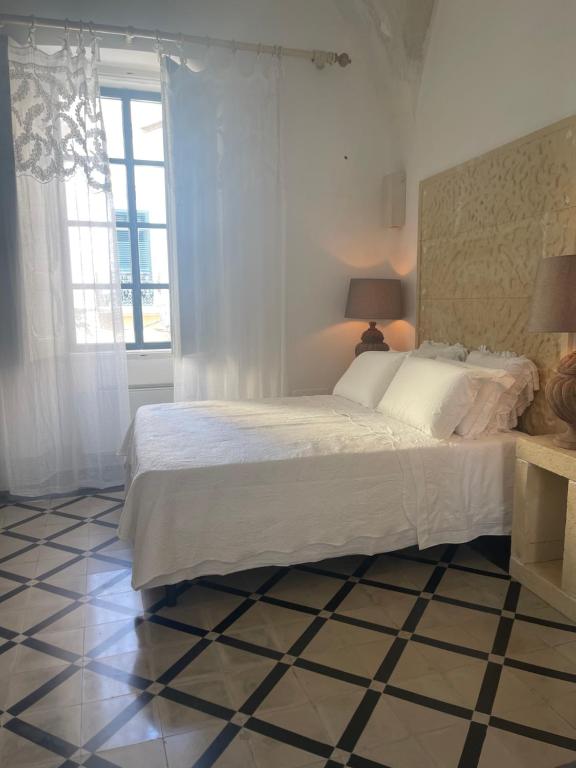 sypialnia z łóżkiem i podłogą wyłożoną kafelkami w obiekcie Palazzo NUR w mieście Gallipoli
