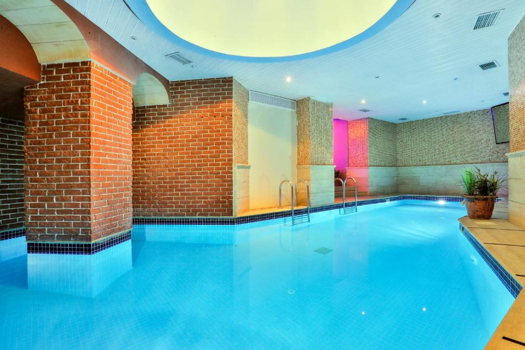 a large swimming pool in a building with a brick wall at Orient Express & Spa by Orka Hotels in Istanbul