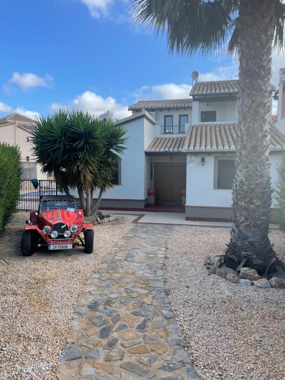 mały czerwony samochód zaparkowany przed domem w obiekcie Impeccable 3-Bed Villa in Hancienda del alamo w mieście Fuente Alamo