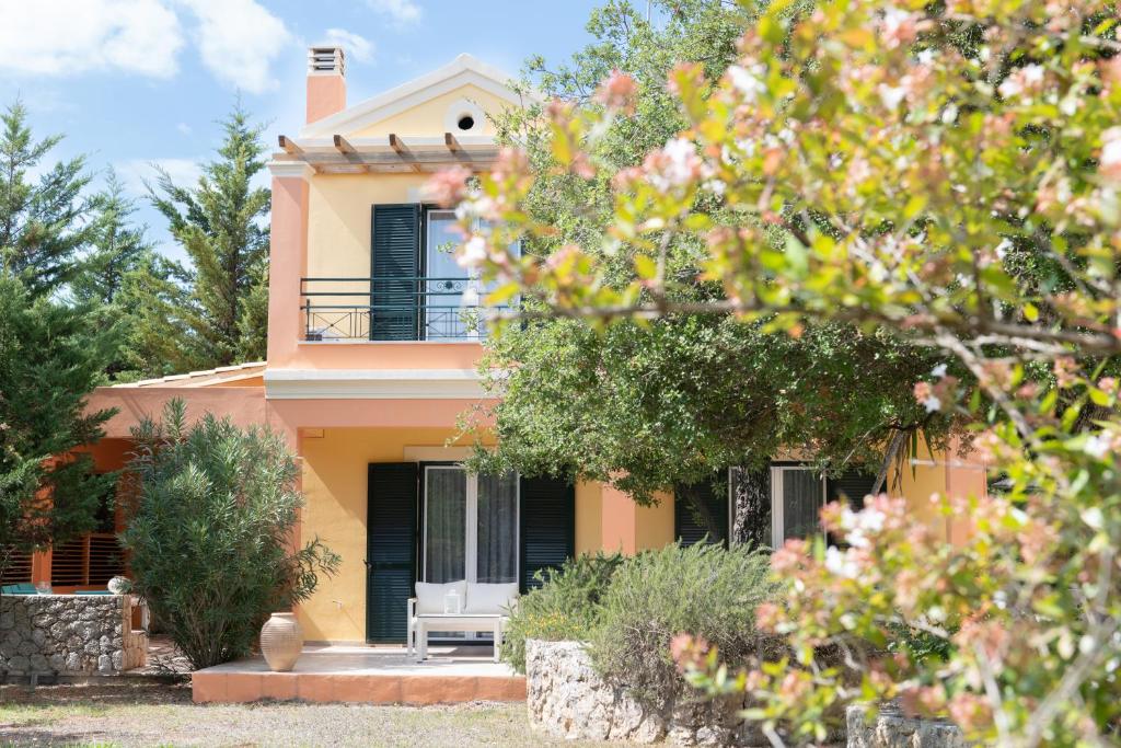 Casa amarilla con porche y balcón en Alexios Villa, en Ágios Ioánnis