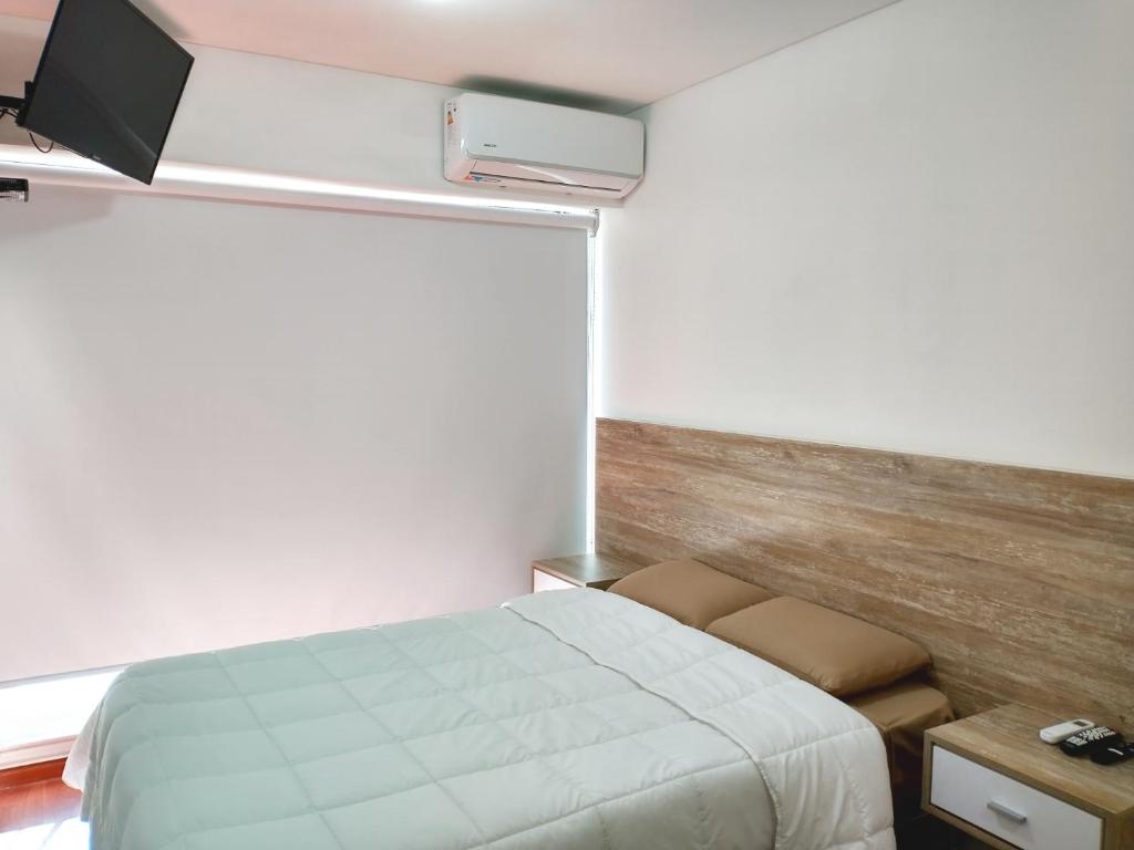 a bedroom with a bed and a flat screen tv at Depto Mancora in Rosario