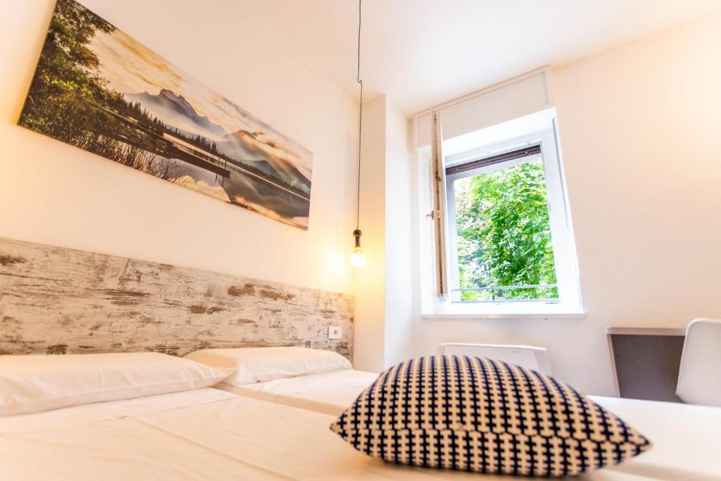 a bedroom with two beds and a window at CASA SAN PAOLO Rooms And Apartments in Trento