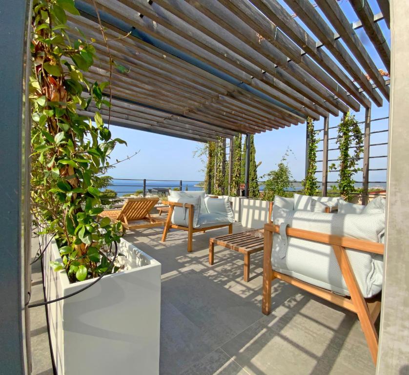 a pergola with chairs and tables on a patio at Divota Townhouse in Split