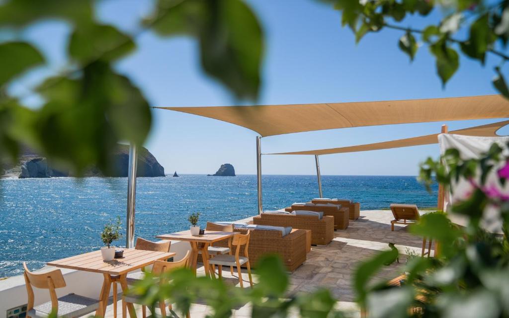 a patio with tables and chairs and the ocean at Melian Boutique Hotel & Spa in Pollonia