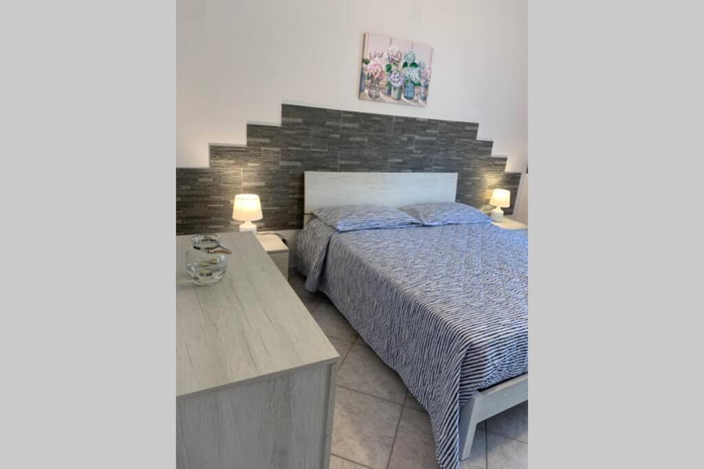 sypialnia z łóżkiem i ceglaną ścianą w obiekcie Casa vacanza - I Mulini con parcheggio gratuito incluso. w mieście Monreale