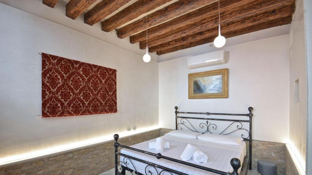 a bedroom with a bed and a painting on the wall at Corte dei Greci in Venice