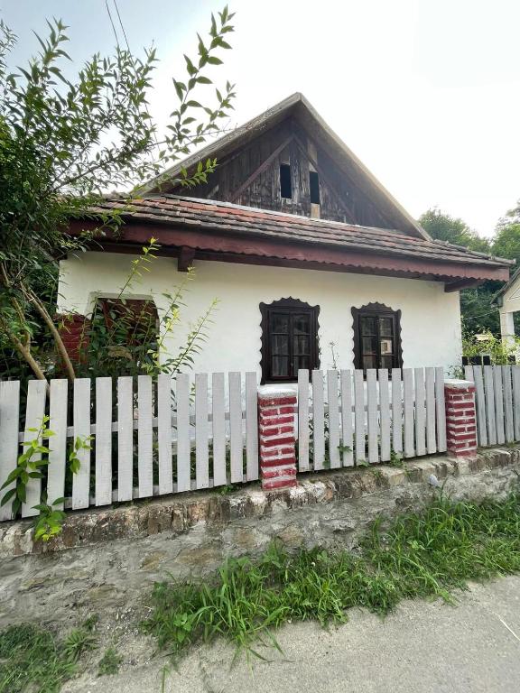 a white picket fence in front of a house at Róza Vendégház in Buják