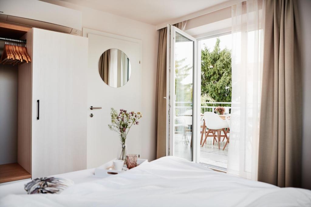 1 dormitorio con 1 cama y puerta corredera de cristal en HOMEBOUND APARTMENTS Salzburg City I - contactless check-in en Salzburgo
