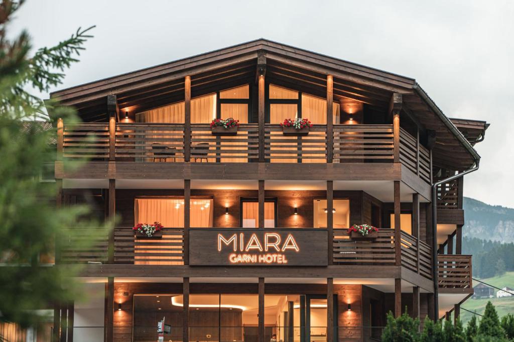 um grande edifício com uma empresa manta assinar nele em Garni Hotel Miara - Your Dolomites Home em Selva di Val Gardena