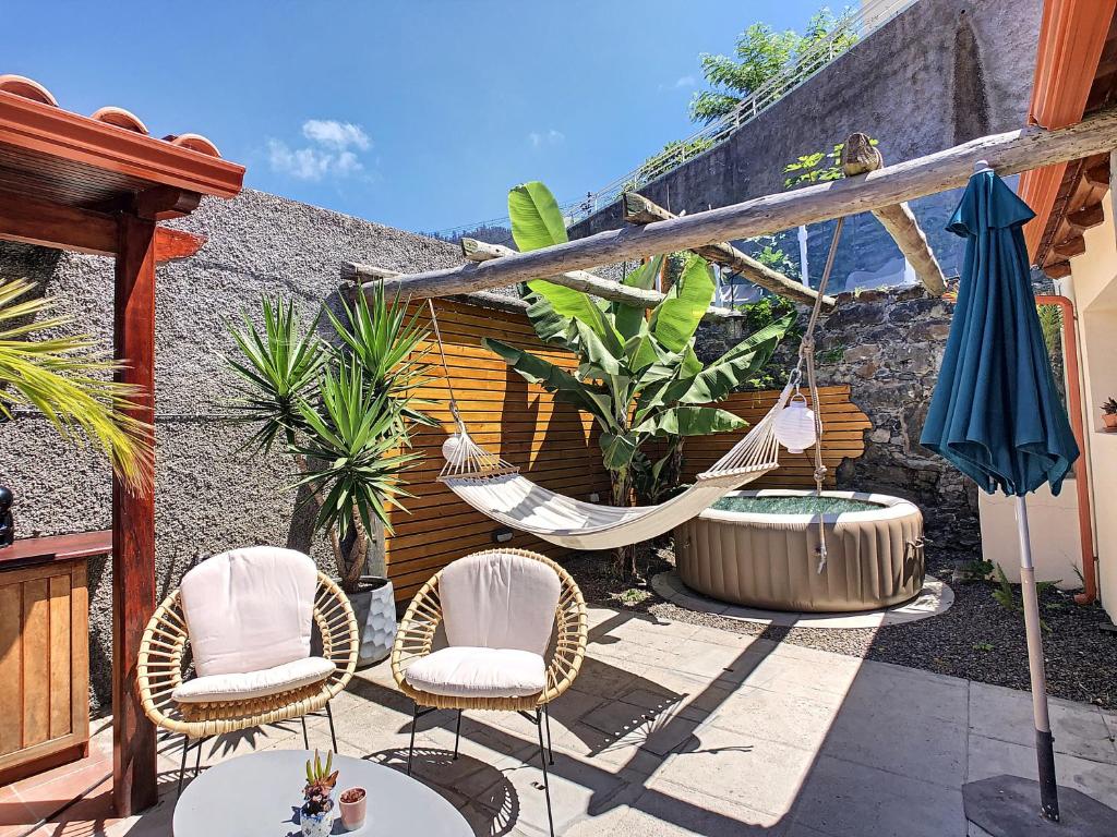 a patio with two chairs and a hammock at Pôr do Sol by LovelyStay in Calheta