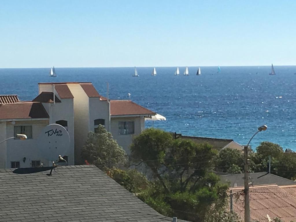 a building with a view of the ocean with sailboats at Casa en Algarrobo Norte in Algarrobo