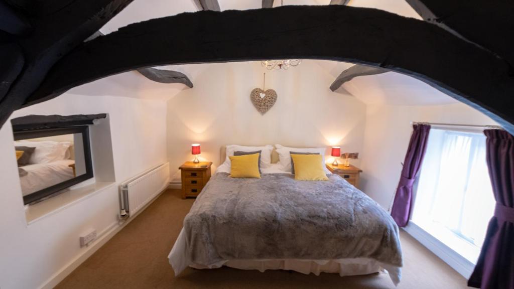 a bedroom with a large bed with yellow pillows at Rowrah Hall - The Old Hayloft in Frizington