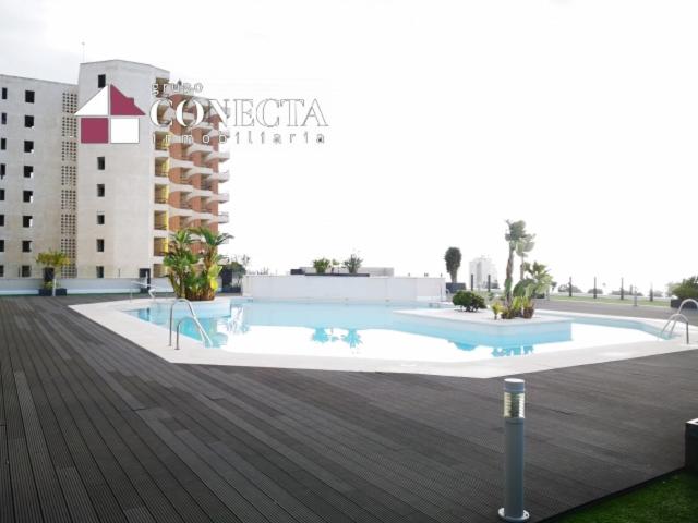 a large swimming pool in front of a building at Attique au soleil in Aguadulce