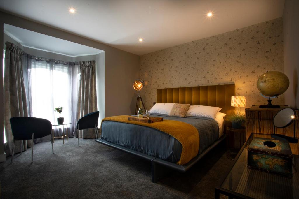 una camera con letto, scrivania e finestra di Broomhill Estate Boutique Art Hotel a Barnstaple
