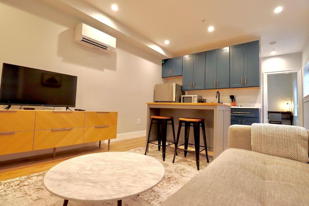 a living room with a couch and a table and a kitchen at The Fairfax Suite at Prince Street Inn in Alexandria