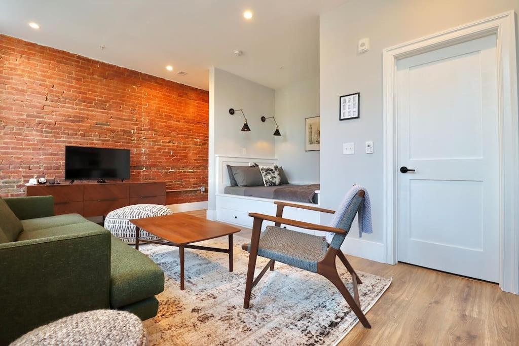 uma sala de estar com um sofá, uma cadeira e uma cama em 9 Suites at Prince Street Inn em Alexandria