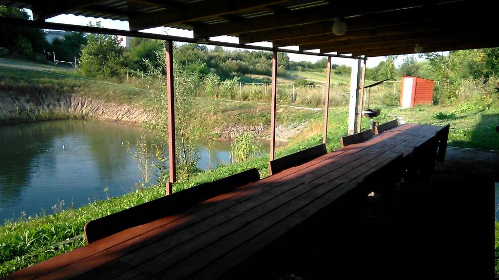 uma doca de madeira com vista para um rio em Barbecue House em Vinnytsya