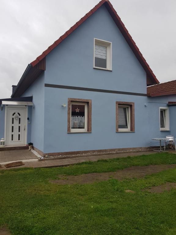 una casa azul con césped delante en Ferienhaus auf Rügen, en Gingst