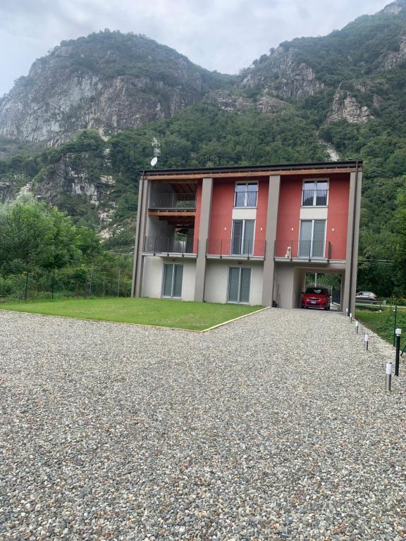 a red building with a mountain in the background at Affittacamere EROI in Verbania