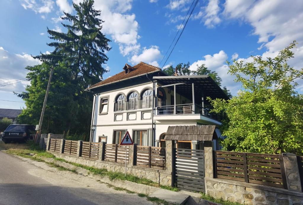 a white house with a fence in front of it at vila zia in Corbeni