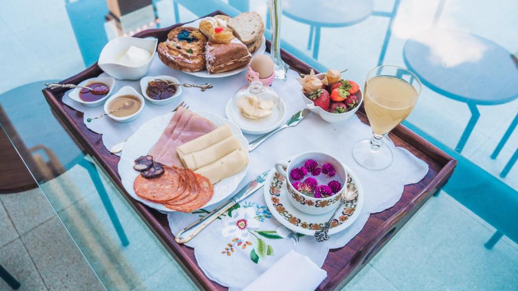 uma mesa com uma bandeja de alimentos e bebidas para o pequeno-almo�o em Arca dos Animais - Farming & SPA em Castelo Branco