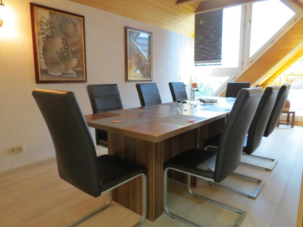 a conference room with a wooden table and black chairs at Penthouse Wolkenstein großzügige Maisonette auf 155 qm mit Whirlpool, Klima & Kamin in Senftenberg