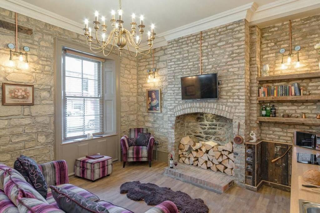 a living room with a stone wall with a fireplace at The Collingwood in Morpeth