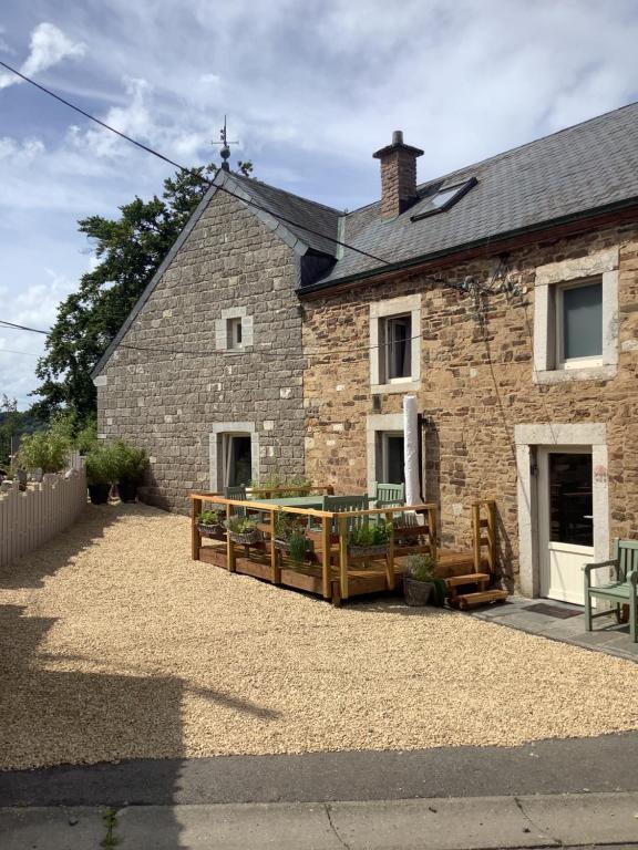 ein Steinhaus mit einer Holzterrasse davor in der Unterkunft La Fagnoul in Ferrières