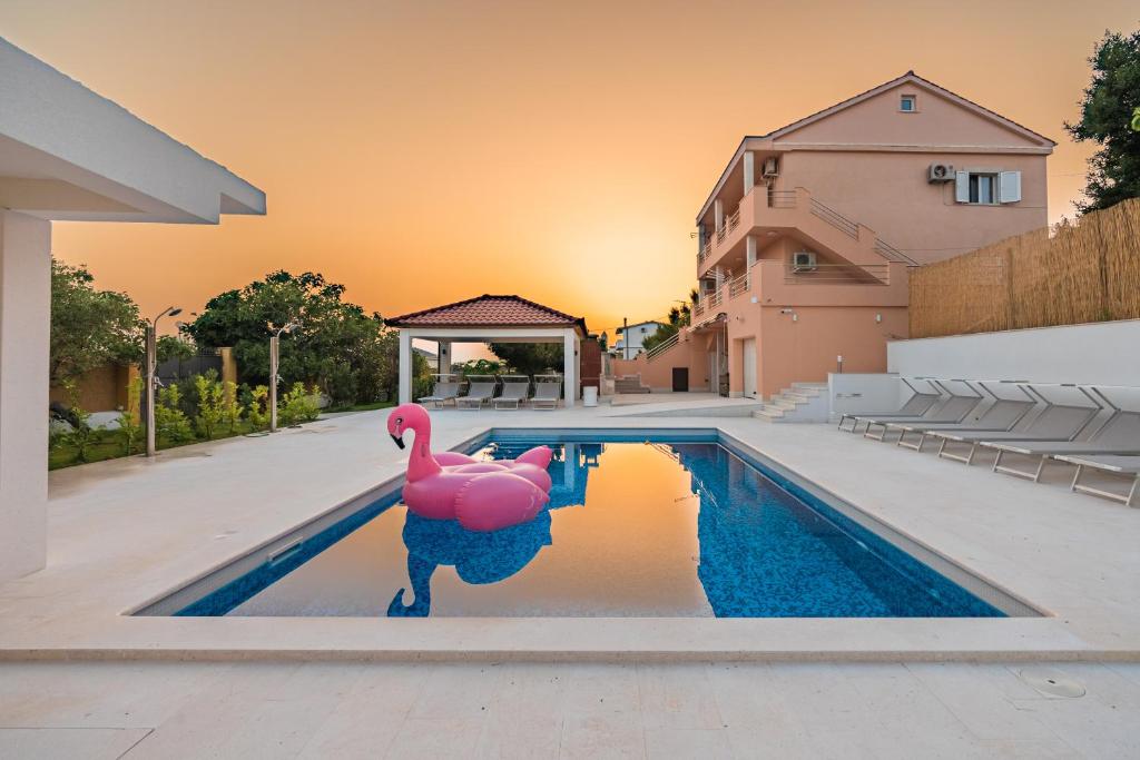 a swimming pool with a pink flamingo in the water at Villa Summer in Rtina