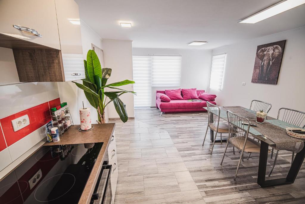 cocina y sala de estar con sofá rosa en CUDERLAND - Petra, en Kobarid