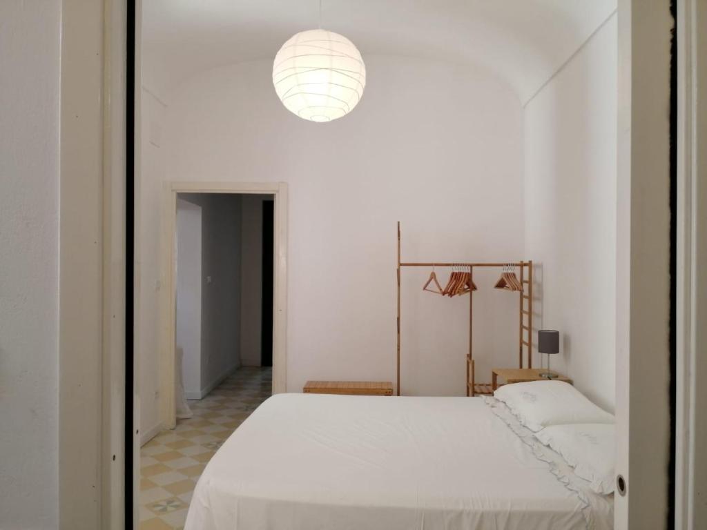 Habitación blanca con cama y luz en Antico Mercato Ortigia Apartment, en Siracusa