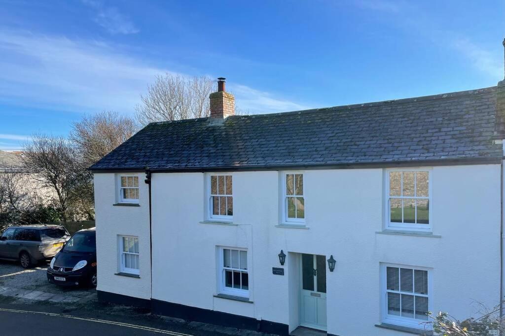 a white house with a black roof at Cornish village house close to beaches & amenities in Porthscatho