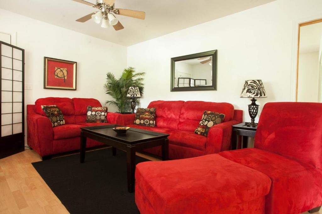 - un salon avec des canapés rouges et une table dans l'établissement 5th Street Ohana, à Volcano