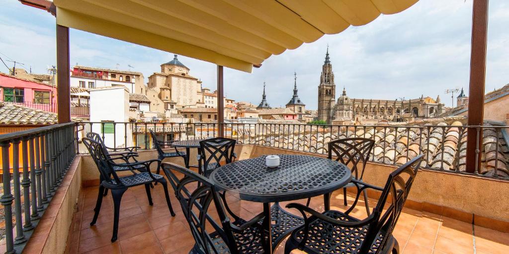 
a patio area with tables, chairs and umbrellas at Hotel Santa Isabel in Toledo
