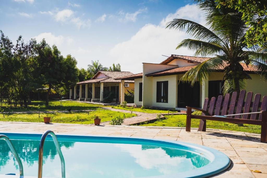 a villa with a swimming pool and a house at Pousada Sitio Parque dos Lençóis in Barreirinhas