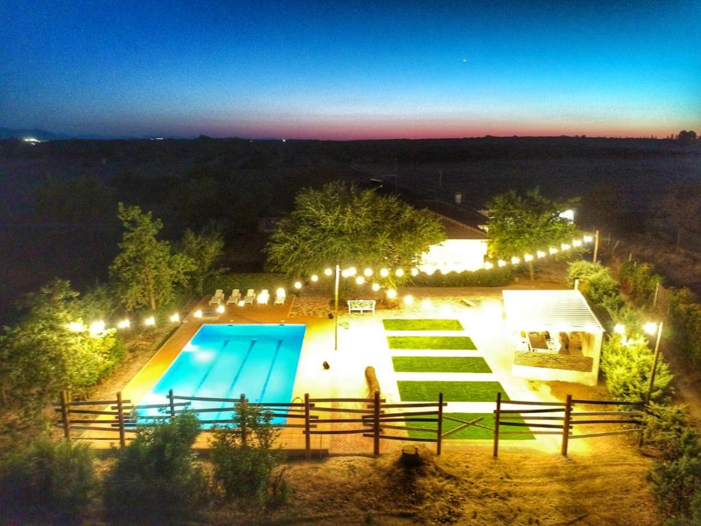 una piscina por la noche con luces en Casa Rural VILLA KAIROS, en Ajofrín