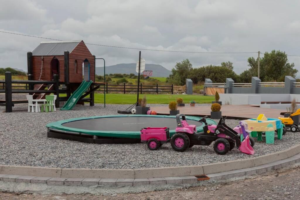 a playground with a toy tractor and a trampoline at Modern Holiday Home - Bundoran in Bundoran