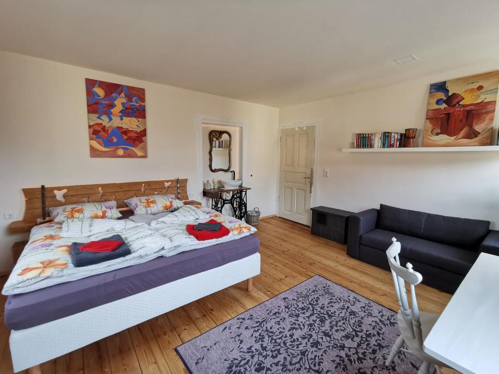 a bedroom with a large bed and a couch at Unser Keltenhof in Niederstetten