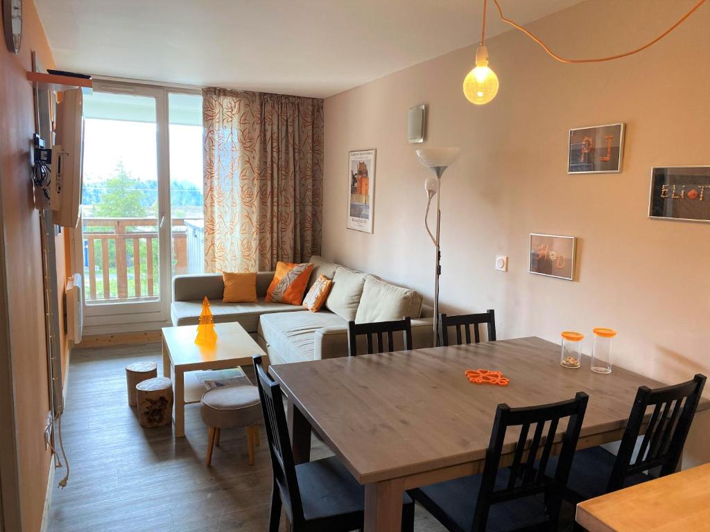 een woonkamer met een tafel en een bank bij Alpes Sweet Home - Le Chrîstiania - Les Bergers in L'Alpe-d'Huez