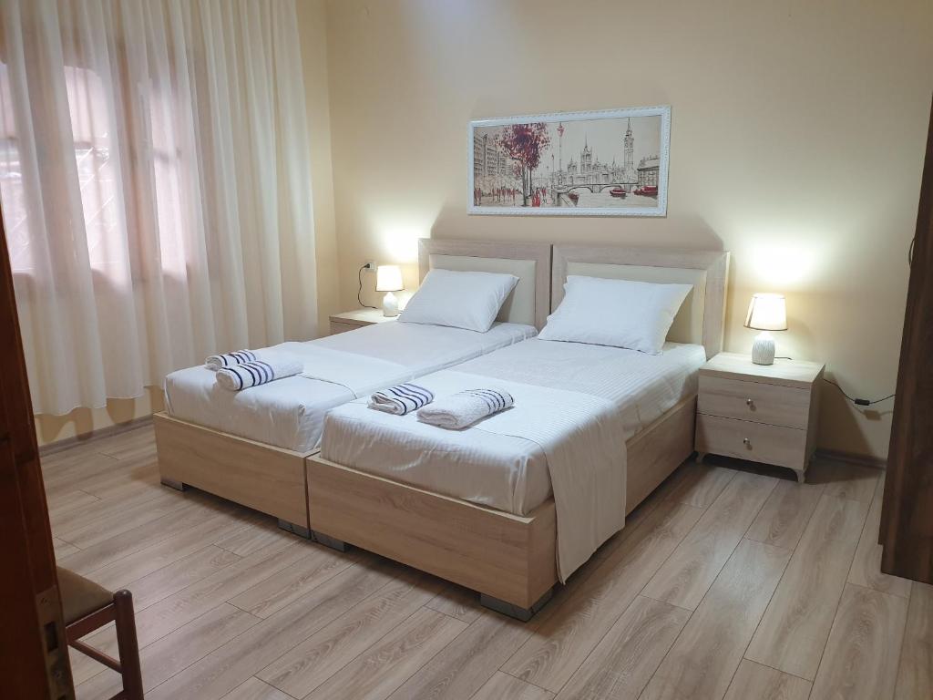 a bedroom with two beds and two night stands at Jordhani's House in Korçë