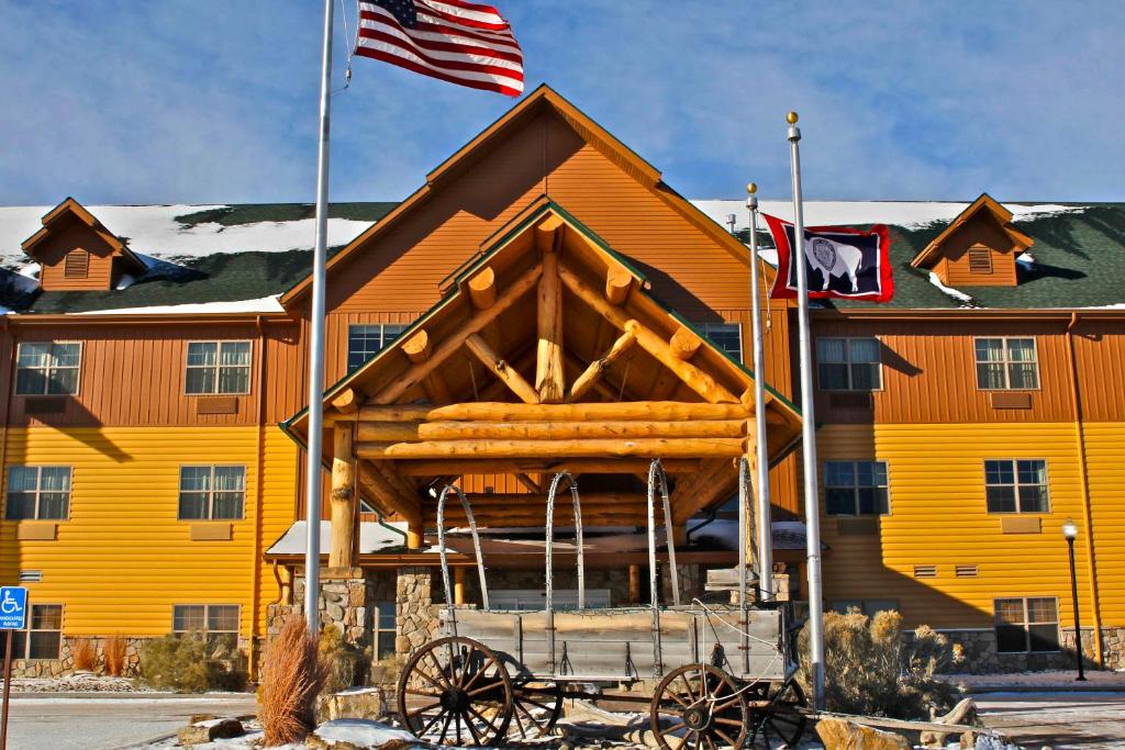 un grand bâtiment jaune drapeau américain dans l'établissement Arbuckle Lodge Gillette, à Gillette