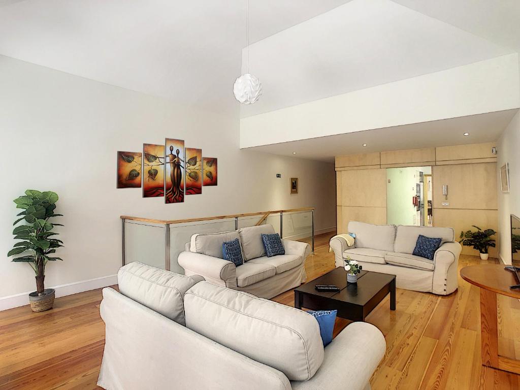 een woonkamer met witte banken en een tafel bij Casa Conceição by LovelyStay in Funchal