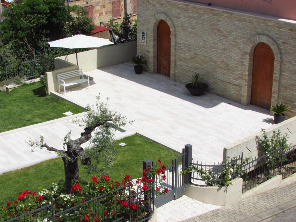 une cour avec un banc et des fleurs rouges dans l'établissement Villa Istonia, à Cupello