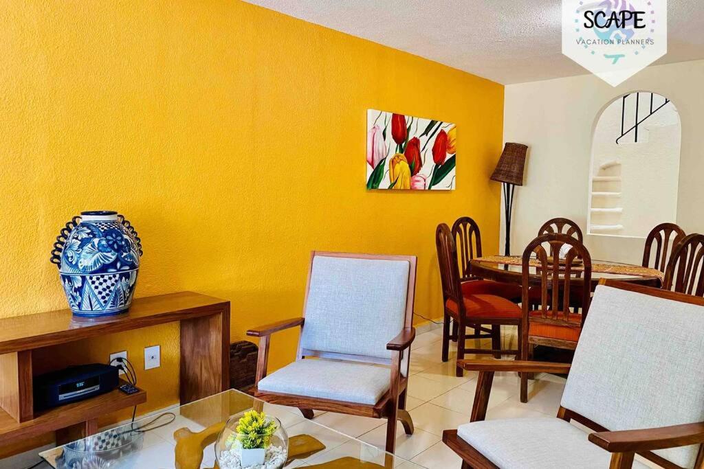 a yellow living room with a table and chairs at AMPLIA Y CÁLIDA CASA cerca de plaza LAS AMERICAS in Cancún