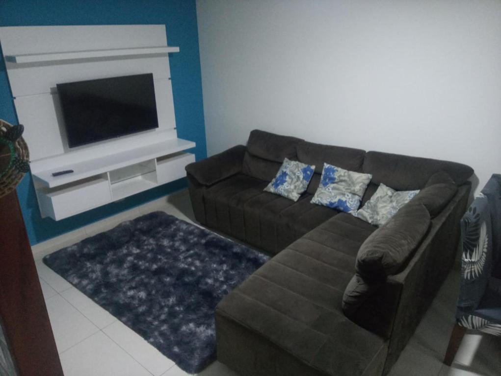 sala de estar con sofá y TV en Bruno Conde Casa na praia en Ubatuba