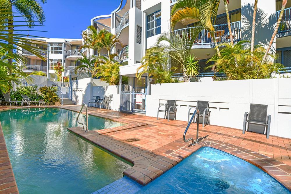 a swimming pool in front of a building at Portobello Resort Apartments in Gold Coast