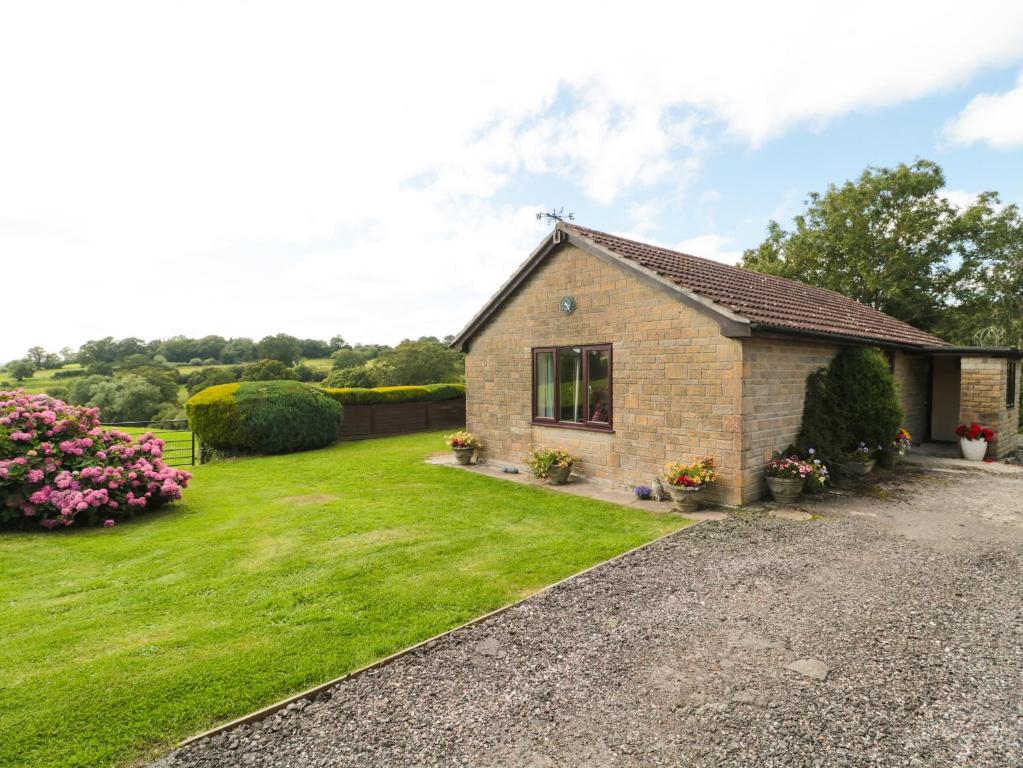 a small brick house with a green yard at Ryecross Farm Cottage in Melbury Abbas