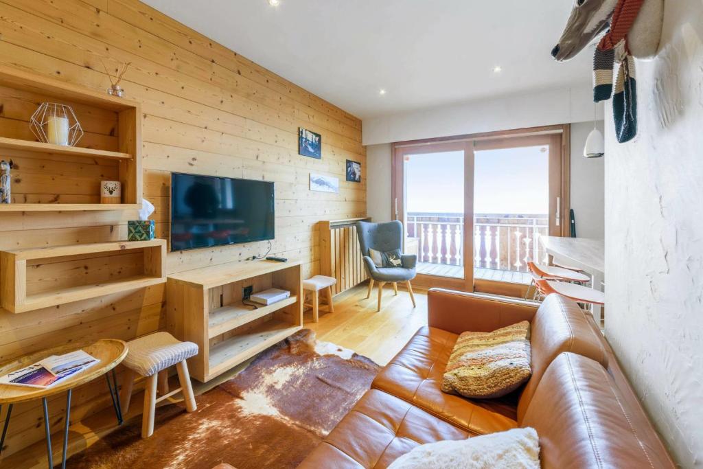 - un salon avec un canapé et une télévision dans l'établissement Cosy flat with terrace in Huez - Welkeys, à Huez